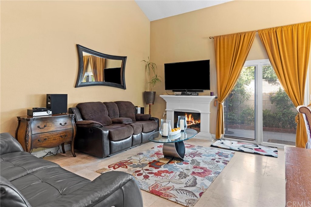 15 Calandria Irvine, CA 92620 - Photo 6 of 49 a living room with furniture a flat screen tv and a fireplace