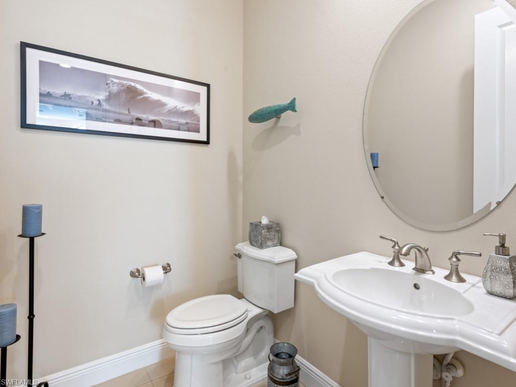 12766 Dundee Lane Naples, FL 34120 - Photo 19 of 37 a bathroom with a toilet sink and mirror