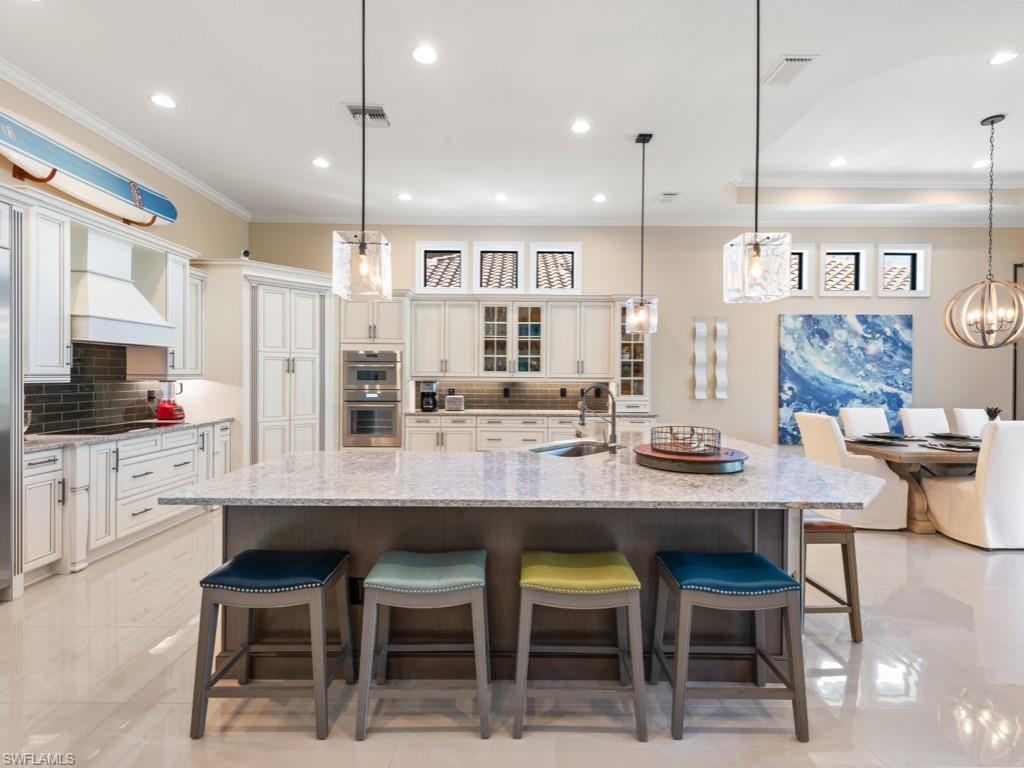 12766 Dundee Lane Naples, FL 34120 - Photo 4 of 37 a kitchen with cabinets and chairs