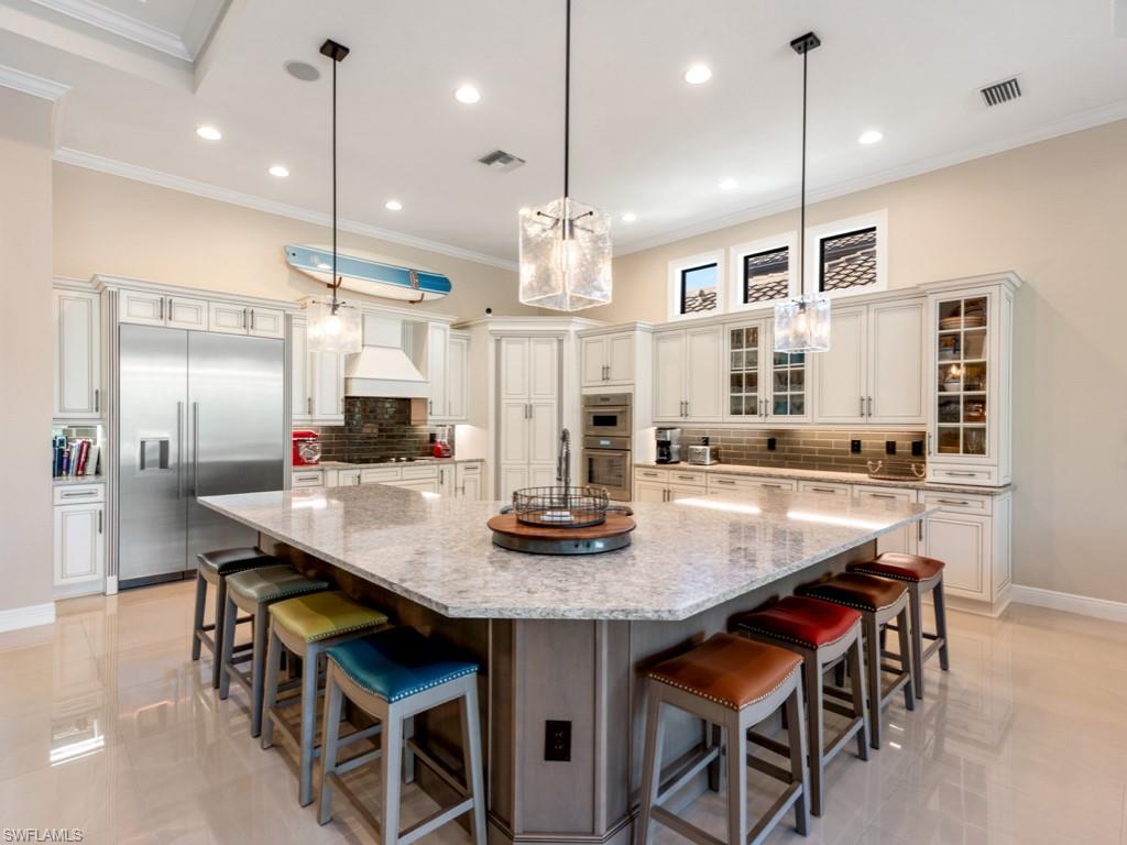 12766 Dundee Lane Naples, FL 34120 - Photo 7 of 37 a kitchen with granite countertop a table chairs stainless steel appliances and cabinets