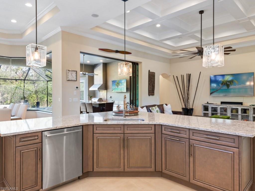 12766 Dundee Lane Naples, FL 34120 - Photo 9 of 37 a kitchen with kitchen island granite countertop a sink a counter space appliances and cabinets