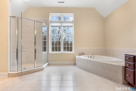 a spacious bathroom with a tub a double vanity sink and a mirror