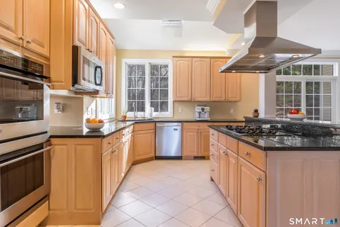 a kitchen with stainless steel appliances granite countertop a sink and a microwave