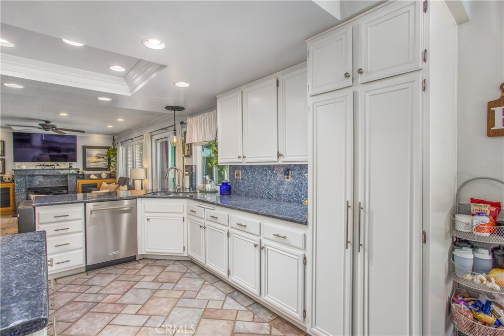 16455 Lake Knoll Parkway Riverside, CA 92503 - Photo 14 of 59 a kitchen with white cabinets a sink dishwasher and a stove with wooden floor