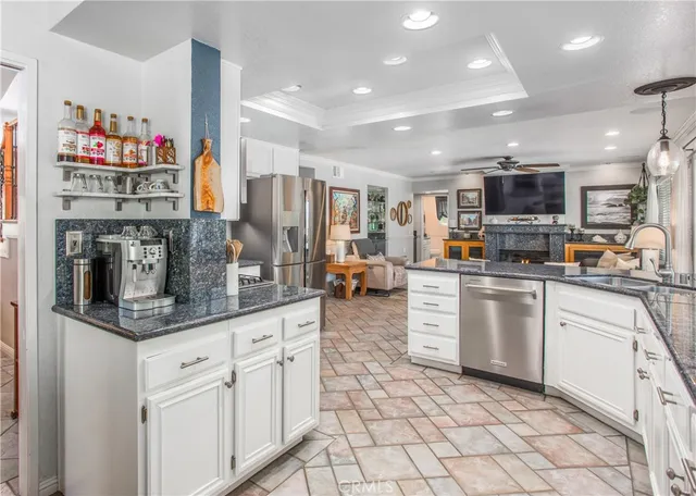a kitchen with stainless steel appliances granite countertop a stove top oven a sink and a refrigerator