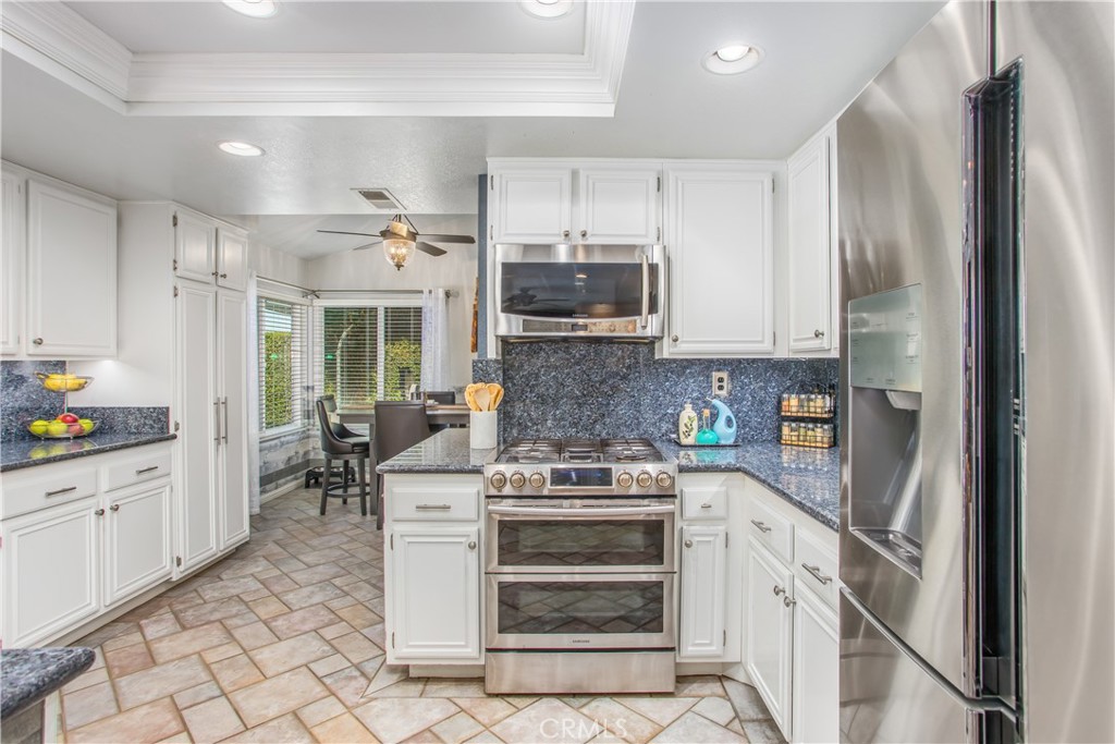 16455 Lake Knoll Parkway Riverside, CA 92503 - Photo 18 of 59 a kitchen with stainless steel appliances granite countertop a stove top oven a sink and a refrigerator