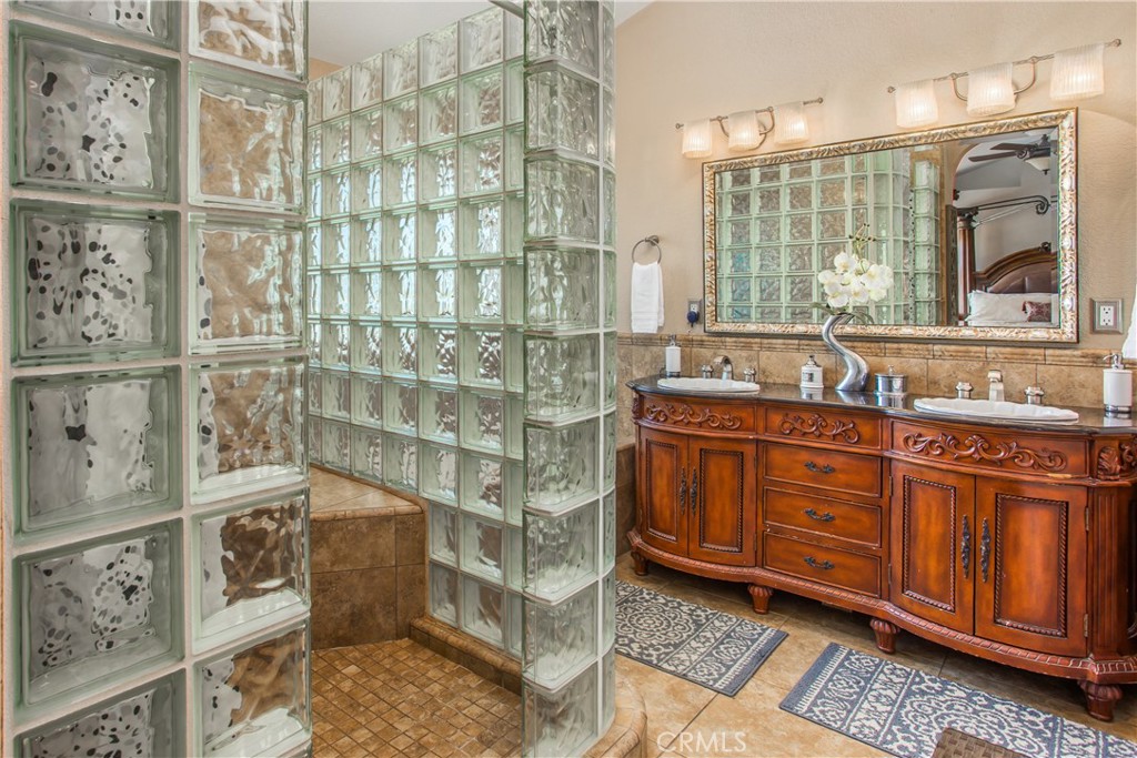 16455 Lake Knoll Parkway Riverside, CA 92503 - Photo 28 of 59 a bathroom with a granite countertop double vanity sink a mirror and shower