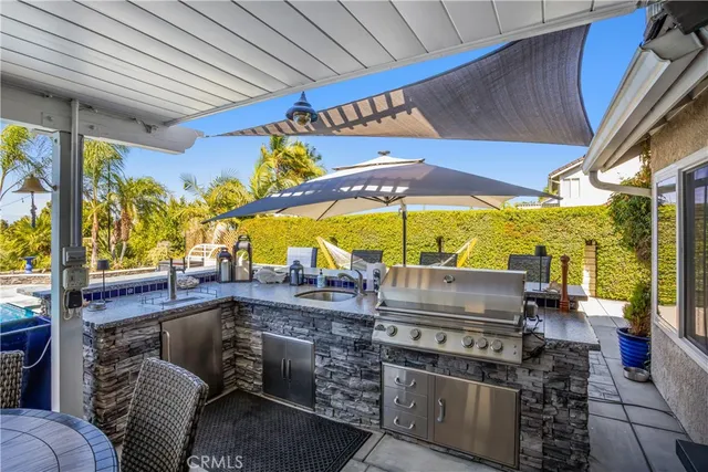 a view of a house with swimming pool lawn chairs under an umbrella