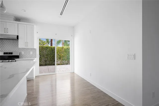 a view of a kitchen with wooden floor and a window