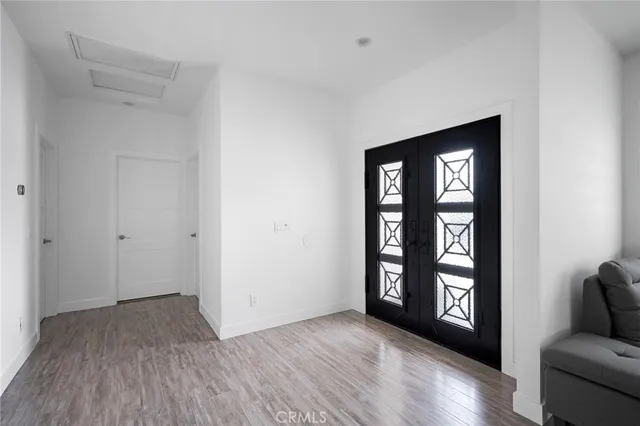 a view of an empty room with window and wooden floor
