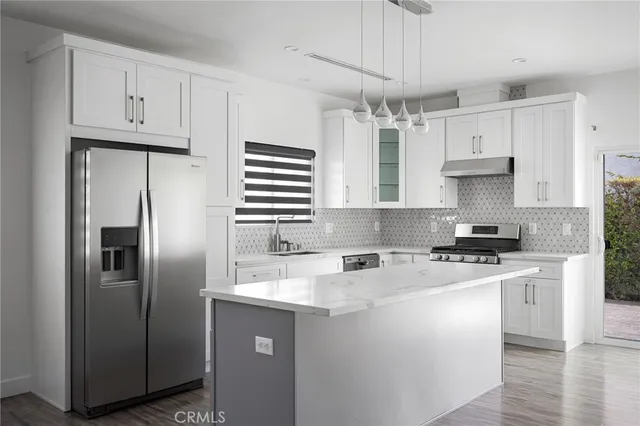 a kitchen with stainless steel appliances granite countertop a stove a sink and a refrigerator