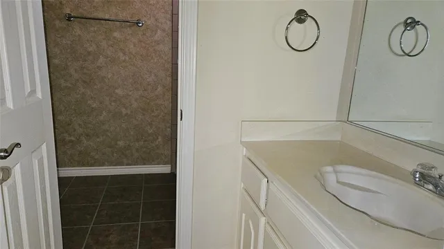 a bathroom with a granite countertop shower and a sink