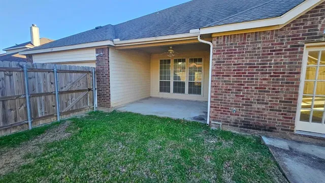 a view of a house with a yard and wooden fence