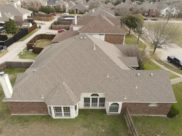 an aerial view of residential houses with outdoor space and parking