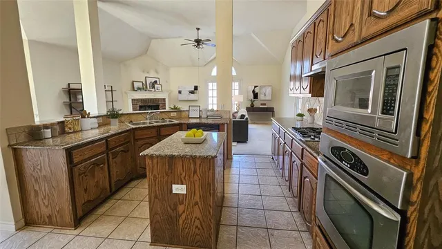 a kitchen with kitchen island a stove sink and cabinets