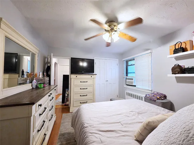 a bedroom with a bed and a flat tv screen on dresser