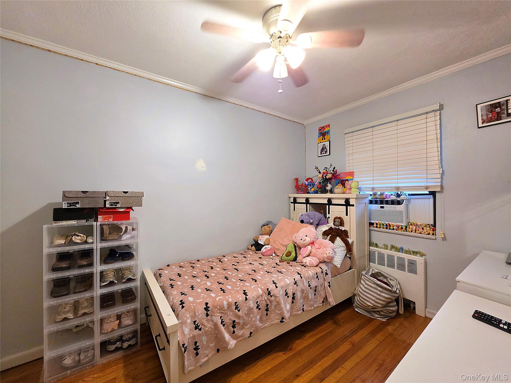 219-12 75th Avenue, Unit LOWR Queens, NY 11364 - Photo 17 of 22 a bedroom with a bed and a bookshelf