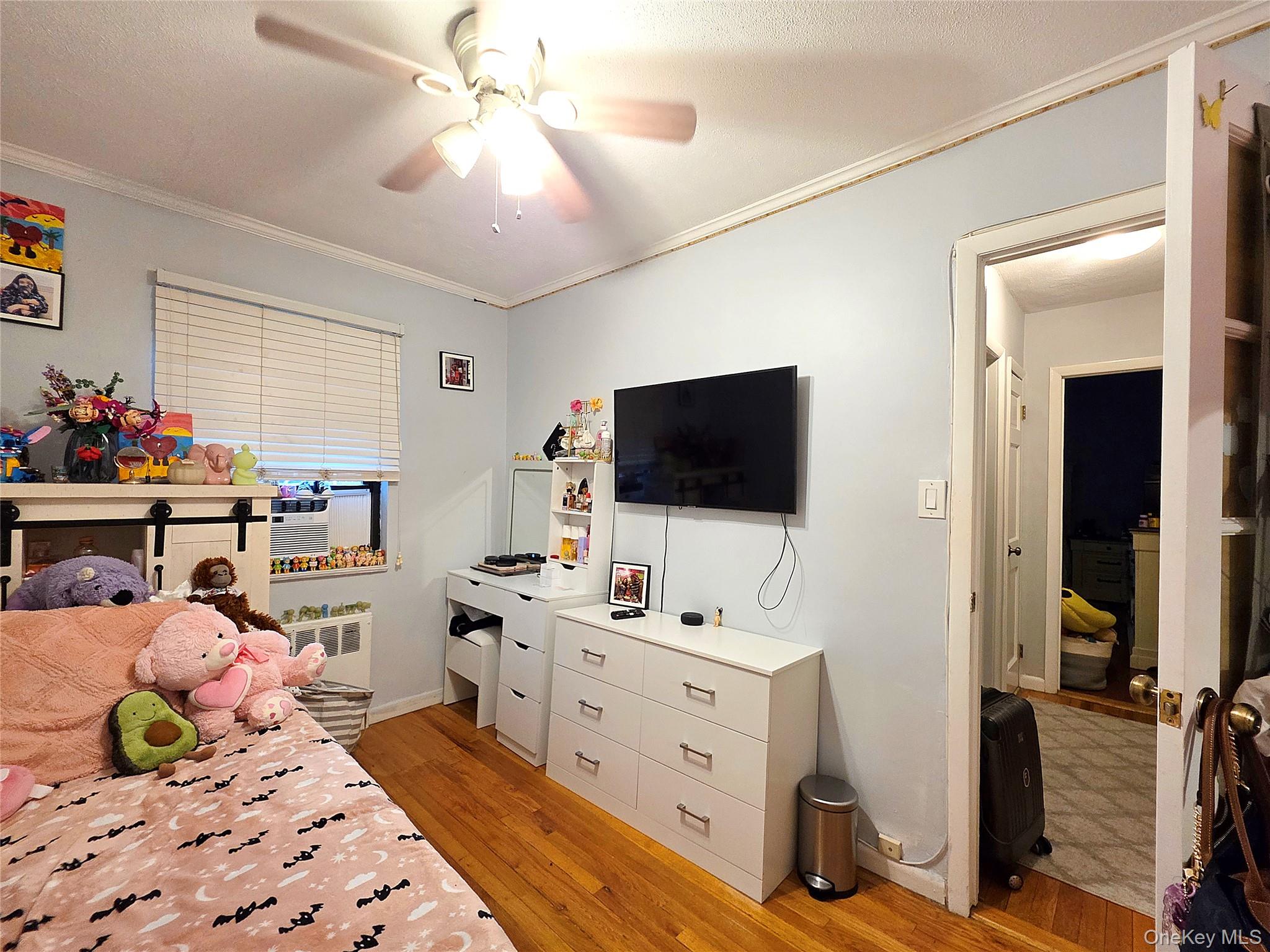 219-12 75th Avenue, Unit LOWR Queens, NY 11364 - Photo 18 of 22 a bedroom with a bed and a flat tv screen
