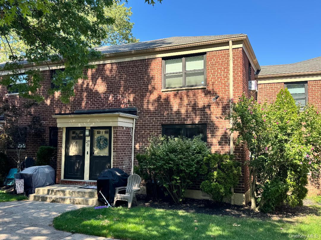 219-12 75th Avenue, Unit LOWR Queens, NY 11364 - Photo 22 of 22 a front view of a house with yard and sitting area