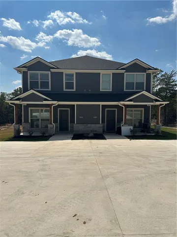 a front view of a house with a yard and parking space
