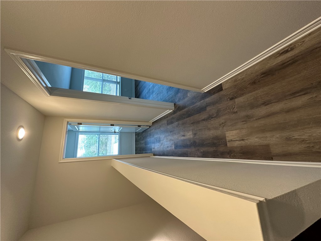 11144-11142 Stillwater Road College Station, TX 77845 - Photo 12 of 22 Hallway featuring dark wood-style flooring and an upstairs landing