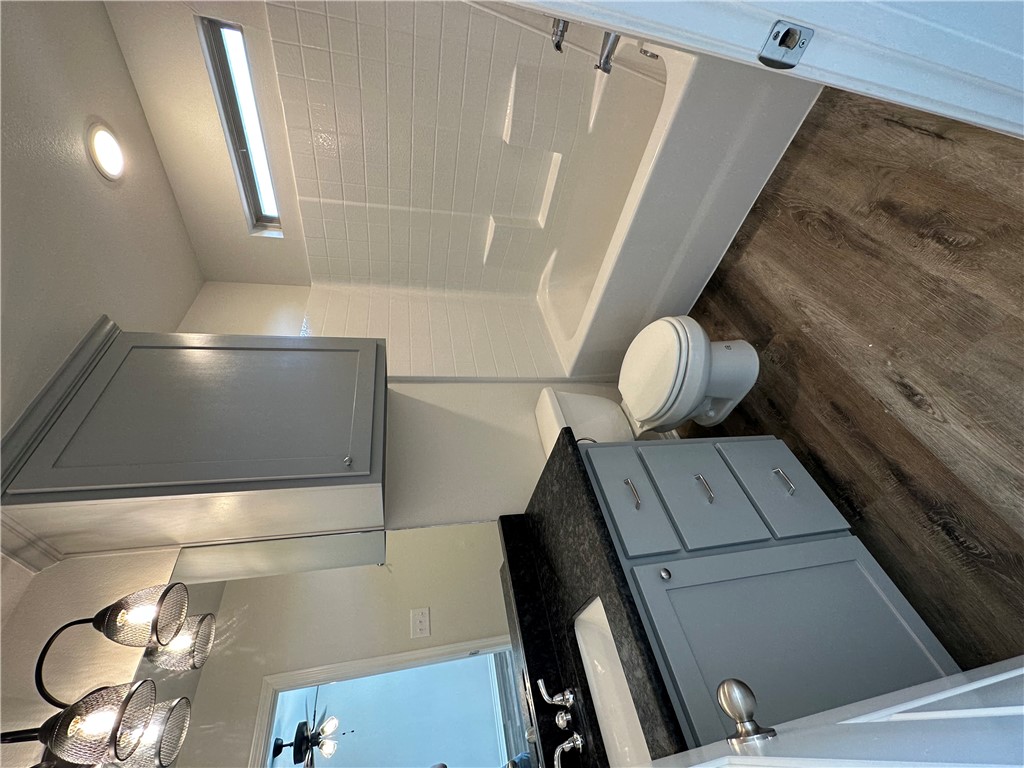 11144-11142 Stillwater Road College Station, TX 77845 - Photo 18 of 22 Full bathroom with dark wood-style floors, vanity, shower / tub combination, and ceiling fan