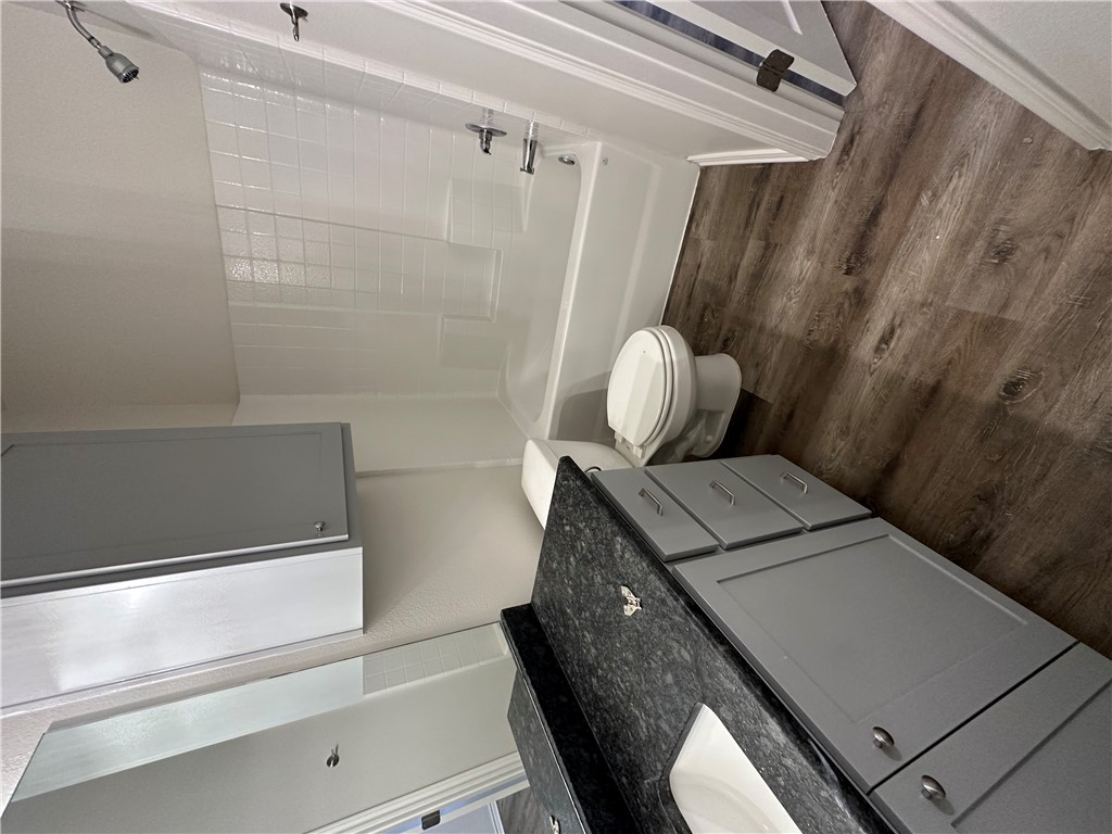 11144-11142 Stillwater Road College Station, TX 77845 - Photo 9 of 22 Full bath with washtub / shower combination, vanity, and dark wood-style floors