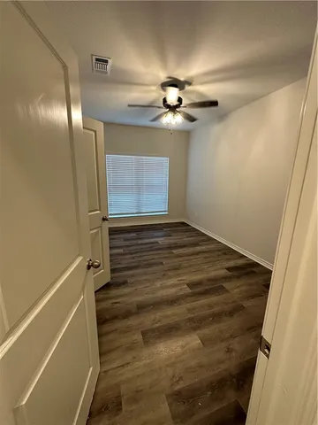 a view of a hallway with wooden floor