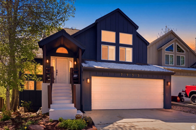 7935 Mustang Loop Road Park City, UT 84098 - Photo 55 of 60 Contemporary exterior featuring dark vertical siding, a two-car garage, a covered front entryway, white trim, and multiple large windows