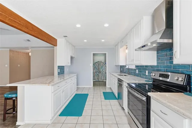 a large kitchen with stainless steel appliances kitchen island granite countertop a sink and cabinets