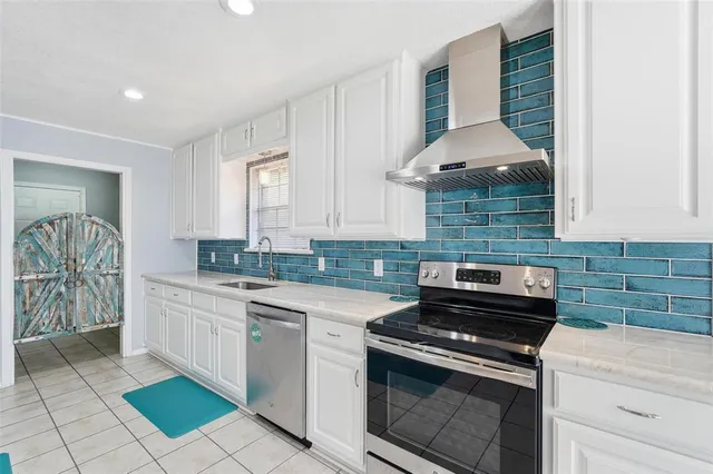 a kitchen with a stove sink and cabinets