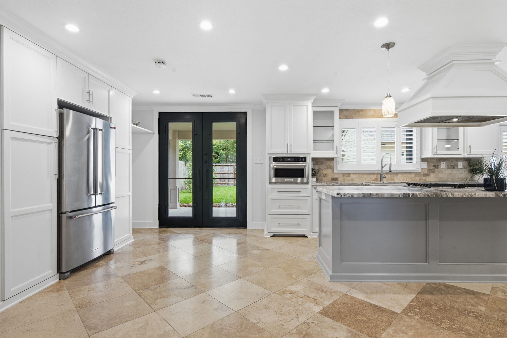 14 Ridgeline Court Spring, TX 77381 - Photo 11 of 40 Sleek white cabinetry, stainless steel appliances, and a large island with gorgeous countertops. Iron French doors open to a lush backyard
