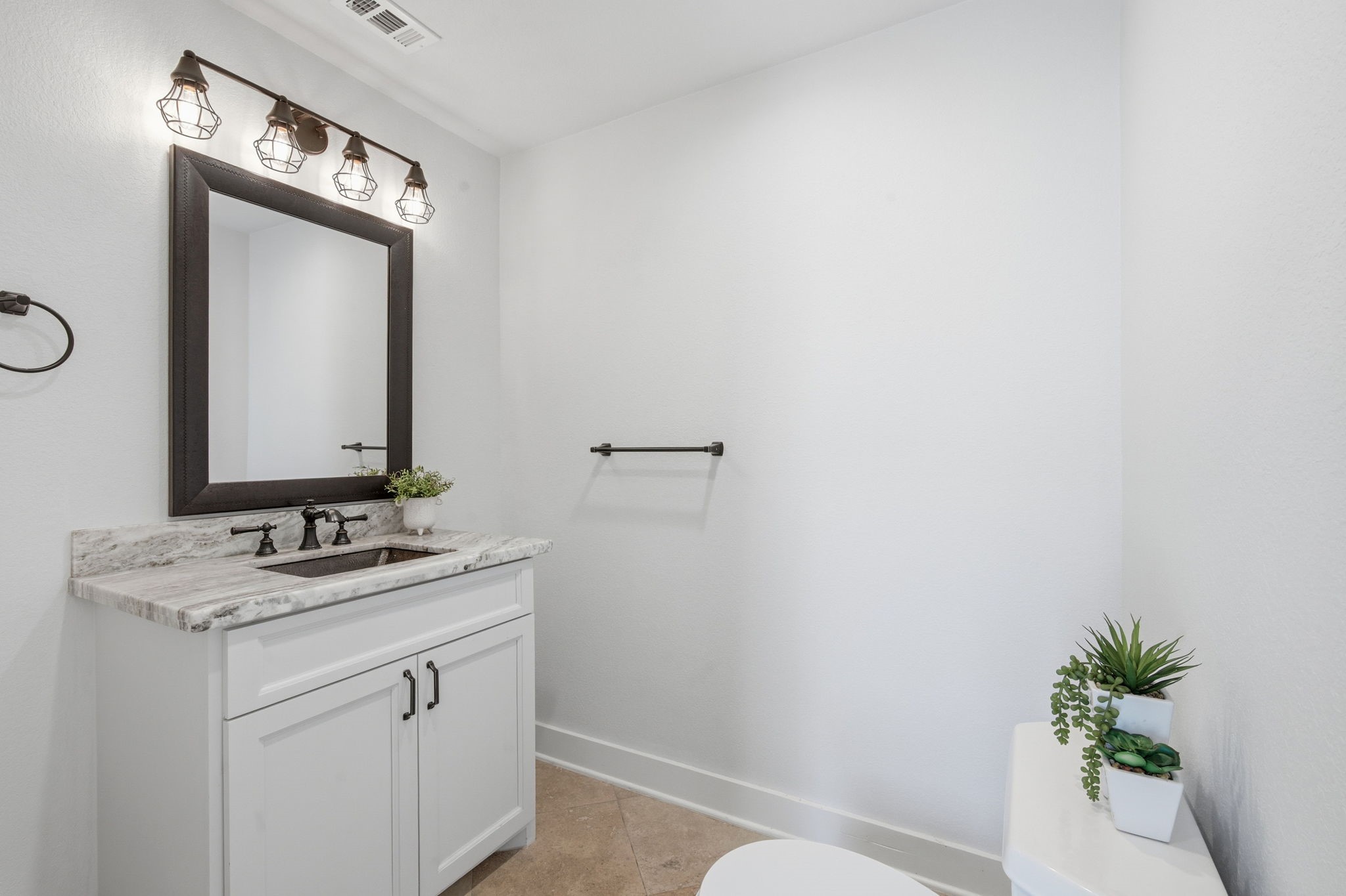 14 Ridgeline Court Spring, TX 77381 - Photo 18 of 40 Totally renovated Half Bath located off the laundry room and breakfast area with hammered copper sinks, beautiful hardware, mirror and lighting. There is a stylish Sliding Bard Door closing them off from the kitchen/breakfast area.