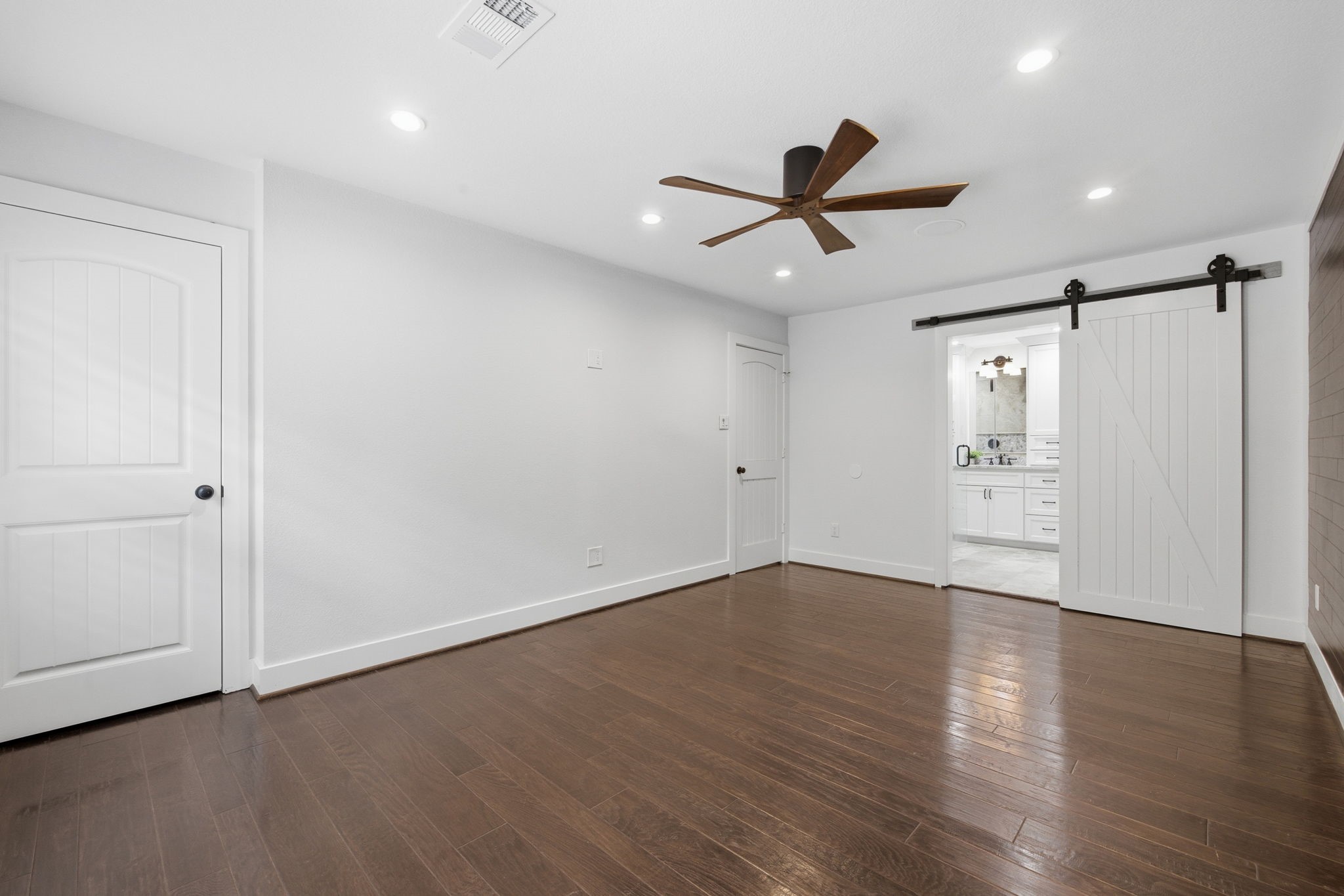 14 Ridgeline Court Spring, TX 77381 - Photo 21 of 40 Another view of the Primary Bedroom showing its stylish sliding barn doors leading to the ensuite bathroom. There is on closet located here and another in the bathroom