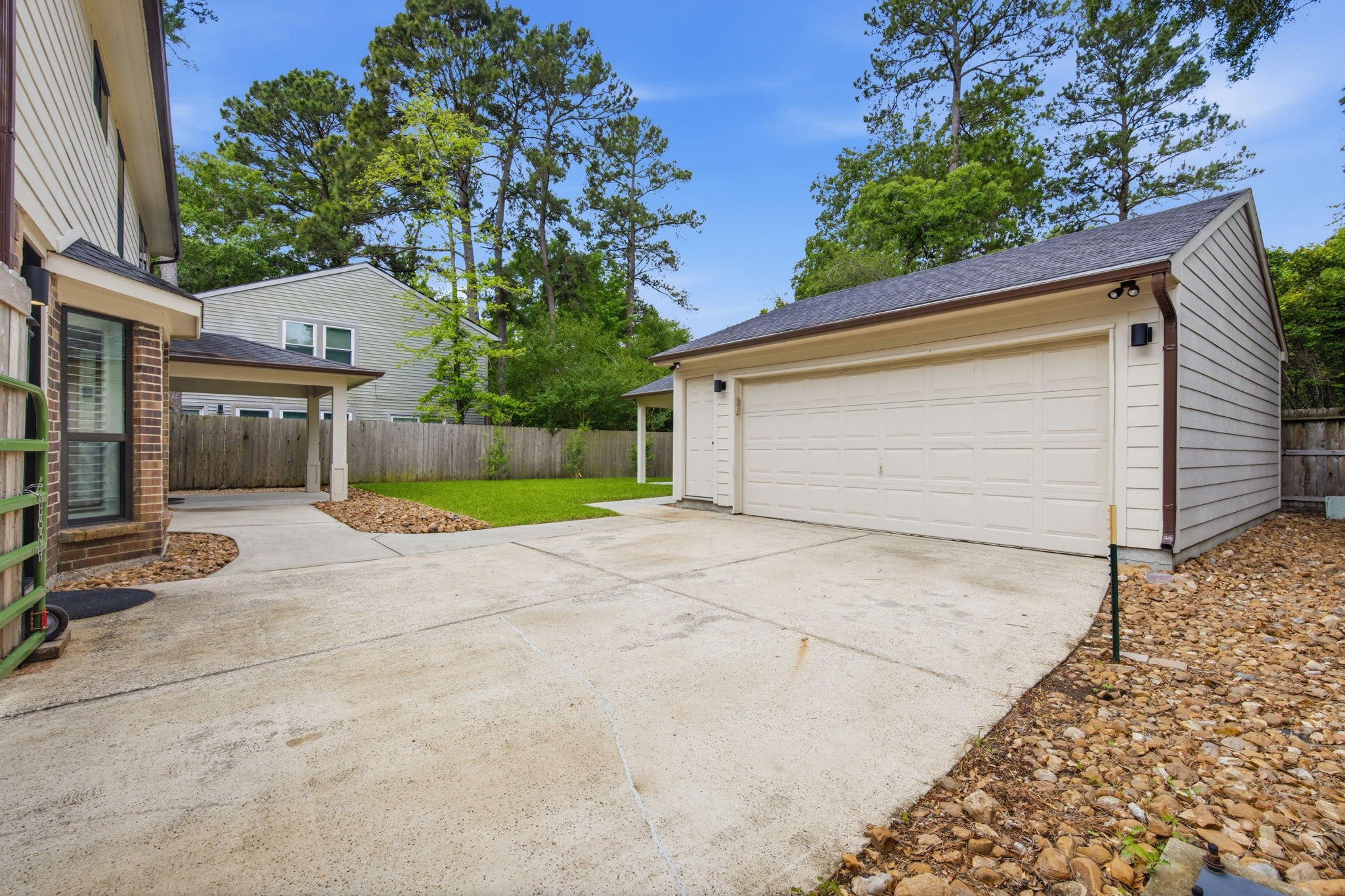 14 Ridgeline Court Spring, TX 77381 - Photo 32 of 40 Here you'll find another view of the detached garage. Garage also has an EV charger, flood lights, updated gutters. The large manual gate encloses the fenced backyard. Backyard backs to a greenbelt buffer.
