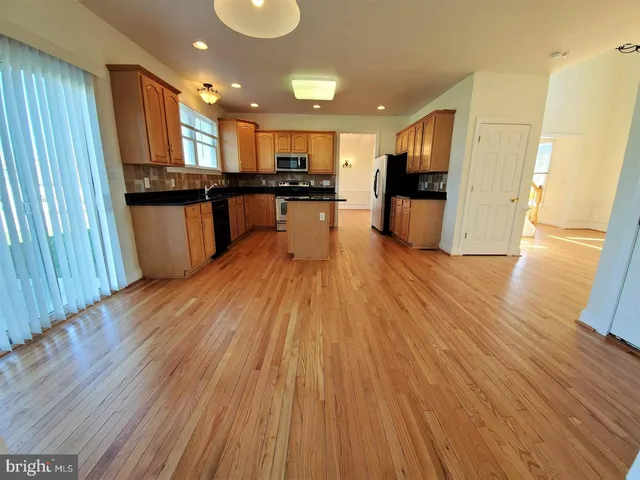 a view of kitchen with refrigerator microwave and stove