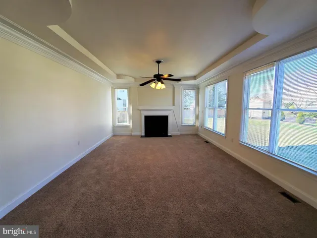 en empty room with windows and fireplace