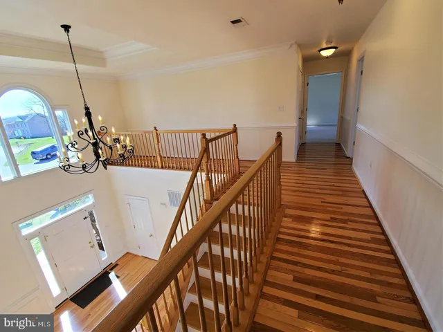 a view of entryway and hall with wooden floor