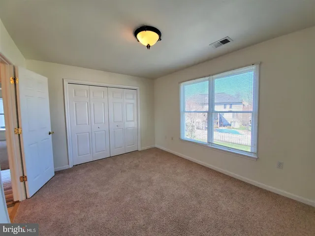 an empty room with windows and closet