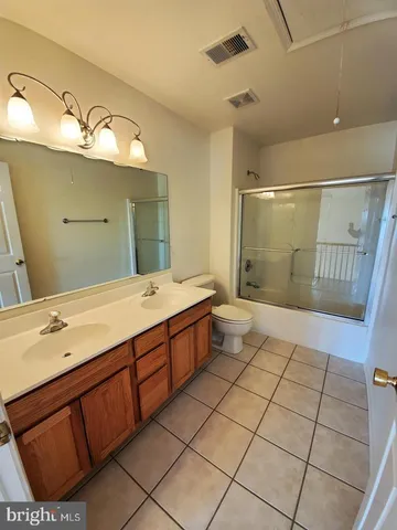 a spacious bathroom with a granite countertop sink a mirror and shower
