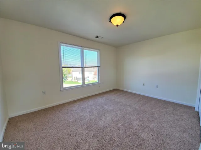 an empty room with windows and mirror