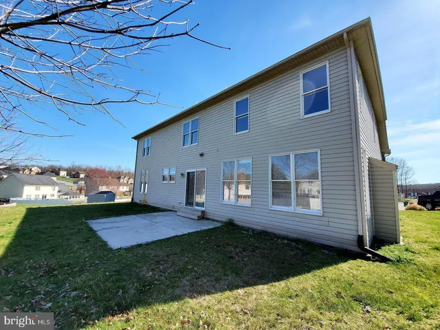 a view of backyard of house with green space