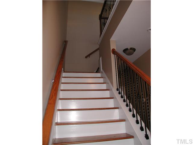 9222 Wooden Road Raleigh, NC 27617 - Photo 3 of 18 Wood tread steps and metal pickets on stairway to second floor. Hardwood floors in foyer.