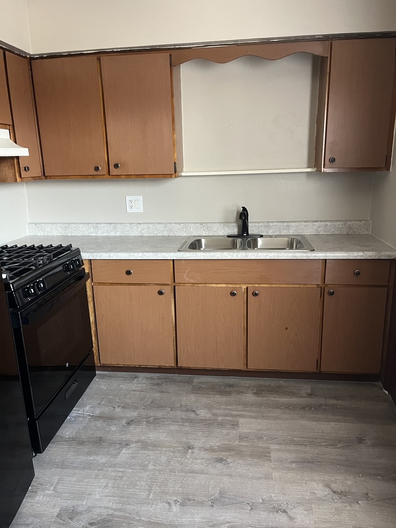 7831 Roberts Road, Unit 3 Bridgeview, IL 60455 - Photo 5 of 7 a kitchen with granite countertop a sink and cabinets