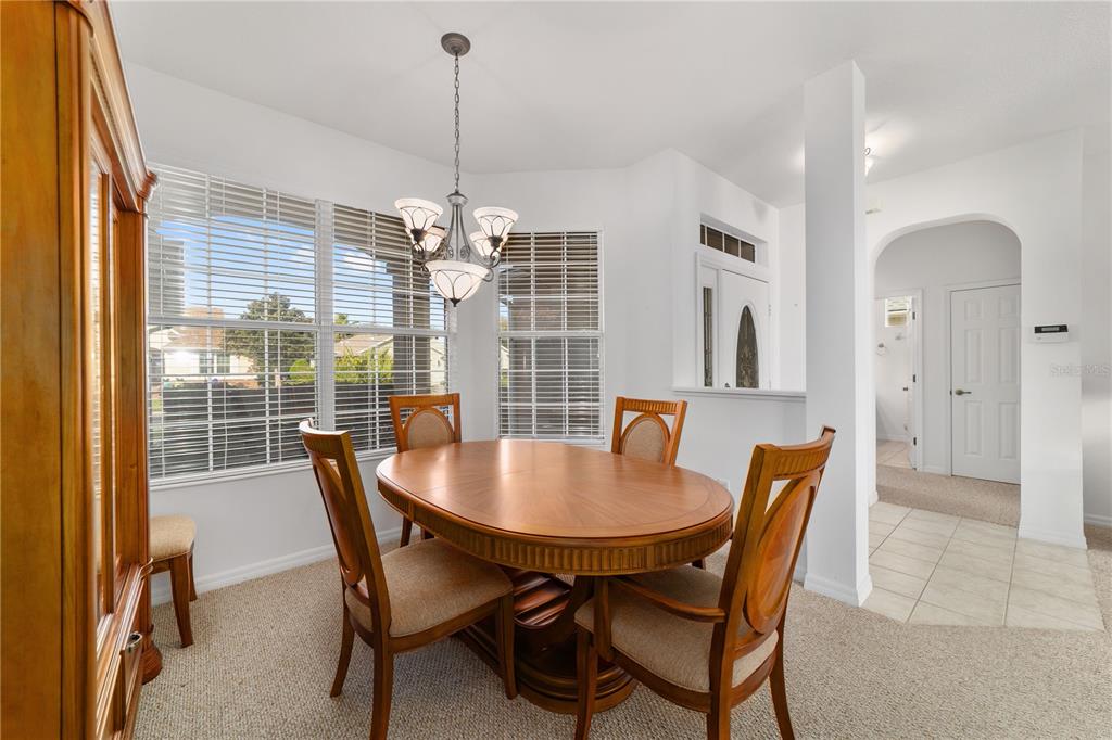 8404 Southwest 82nd Circle Ocala, FL 34481 - Photo 21 of 58 a dining room with furniture a chandelier and wooden floor