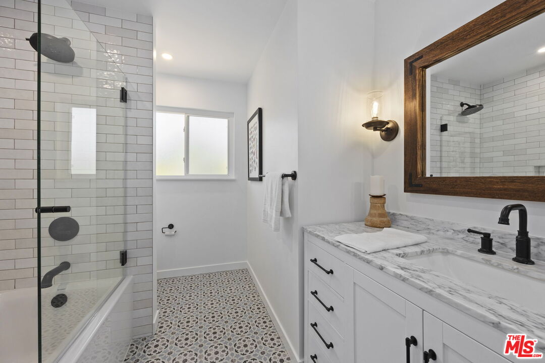 431 Montana Circle Ojai, CA 93023 - Photo 28 of 73 a bathroom with a granite countertop sink a mirror a glass door a shower and vanity
