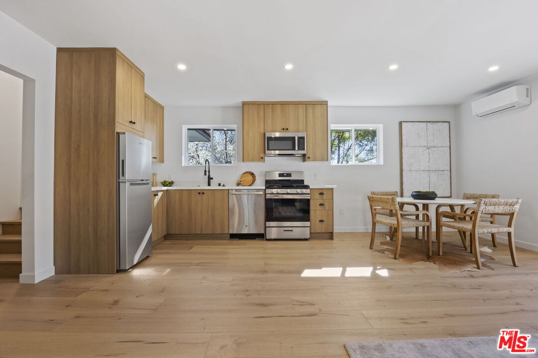 431 Montana Circle Ojai, CA 93023 - Photo 58 of 73 a kitchen with stainless steel appliances granite countertop a stove top oven a sink dishwasher a dining table and chairs with wooden floor