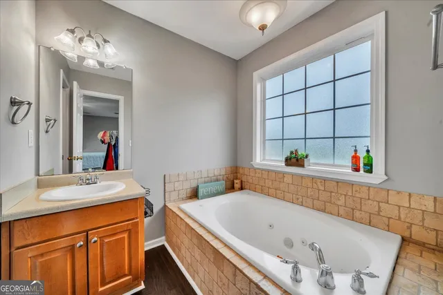a bathroom with a tub a sink and a window