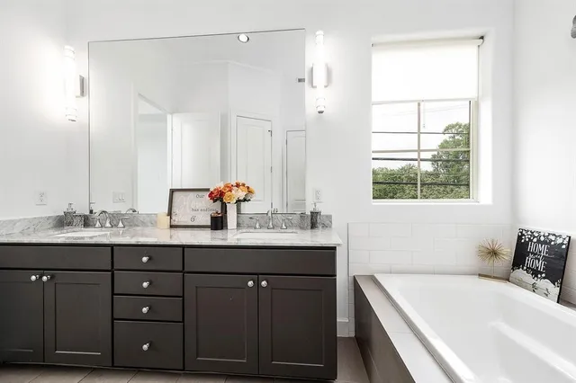 a bathroom with a tub sink and mirror