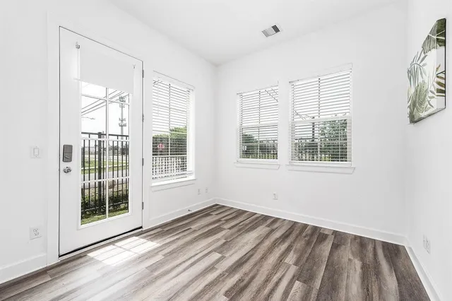 a view of a livingroom with wooden floor and windows